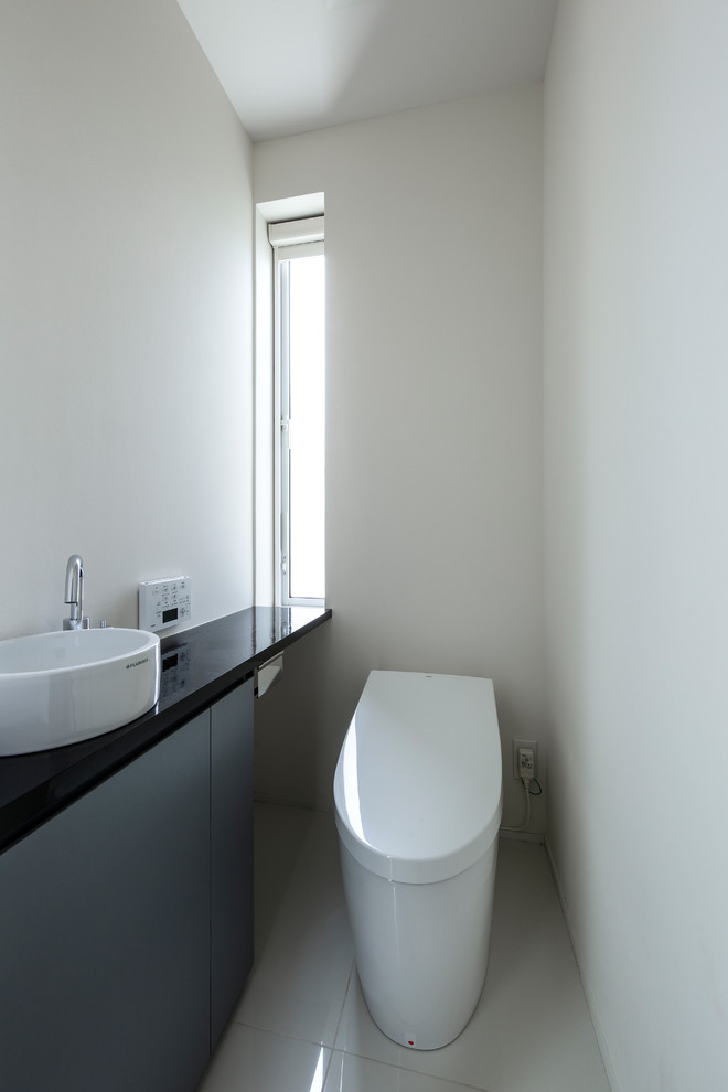 This is an example of a small modern powder room in Other.