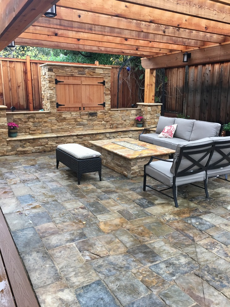 Photo of a mid-sized traditional backyard patio in Orange County with natural stone pavers and a pergola.