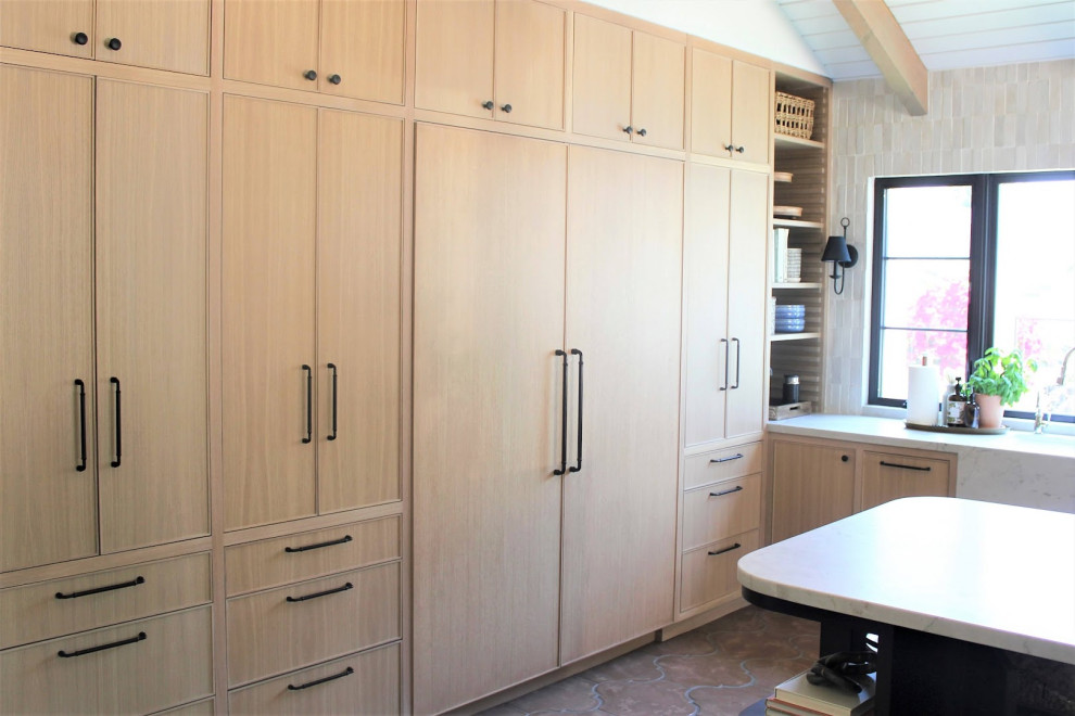 Inspiration for a medium sized modern l-shaped kitchen pantry in Orange County with a belfast sink, shaker cabinets, light wood cabinets, laminate countertops, multi-coloured splashback, ceramic splashback, stainless steel appliances, cement flooring, an island, brown floors, white worktops and a wood ceiling.