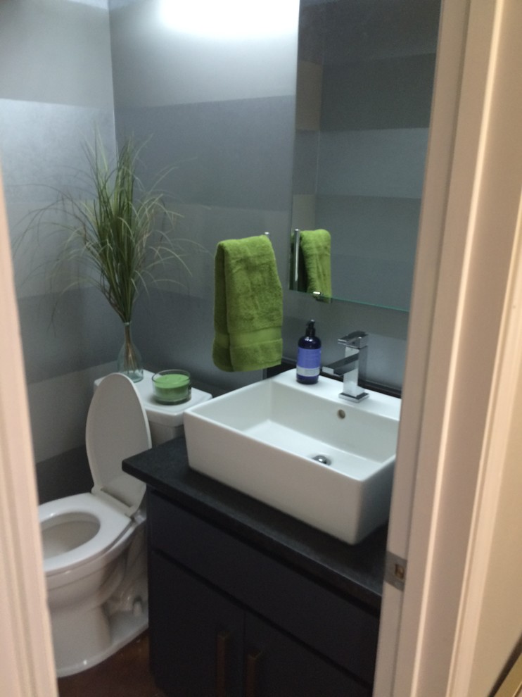 Photo of a small contemporary bathroom in Austin with shaker cabinets, blue cabinets, a two-piece toilet, blue walls, concrete floors, a vessel sink, red floor and black benchtops.