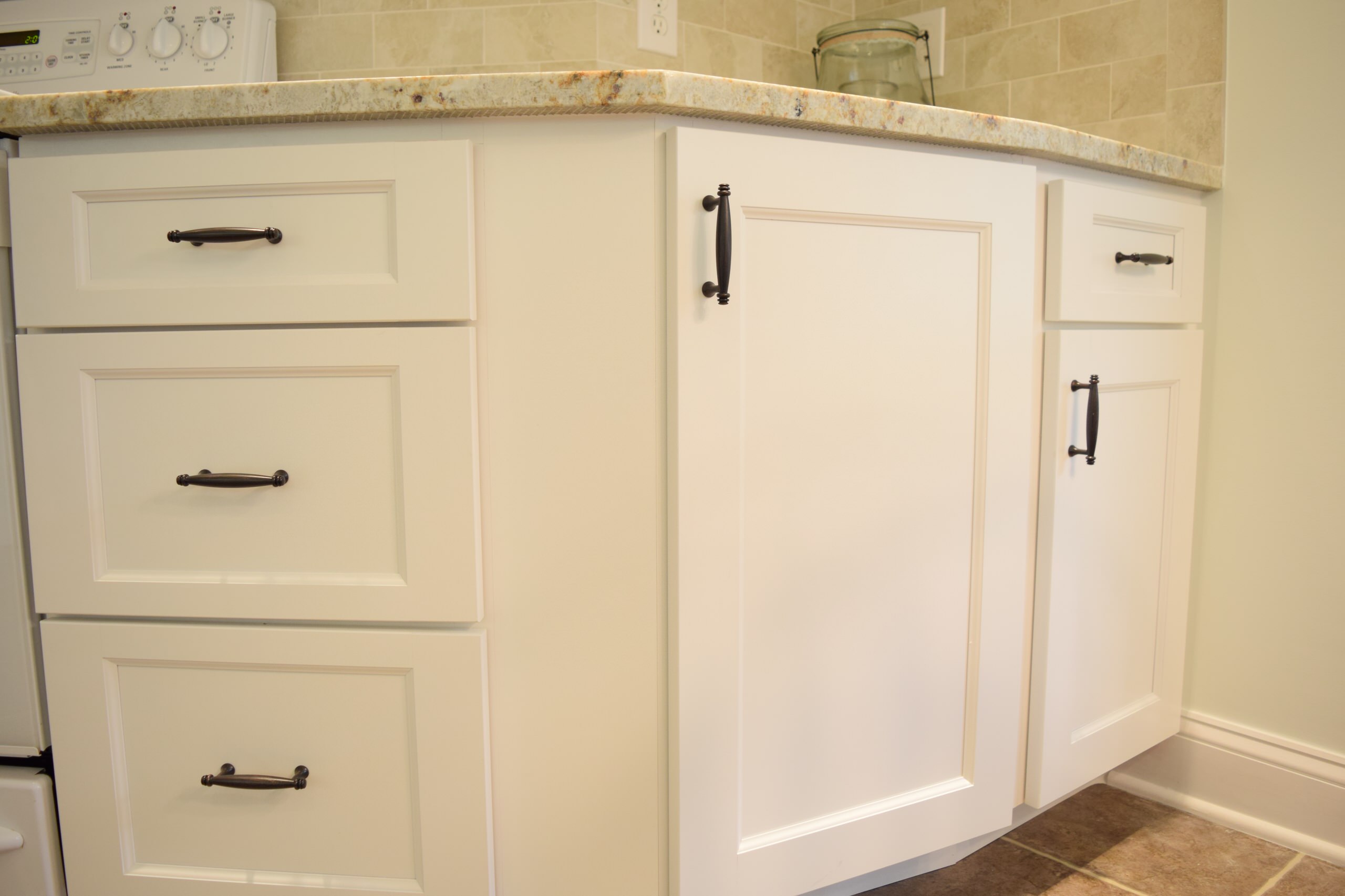 White kitchen with oil rubbed cabinet drawer pulls.