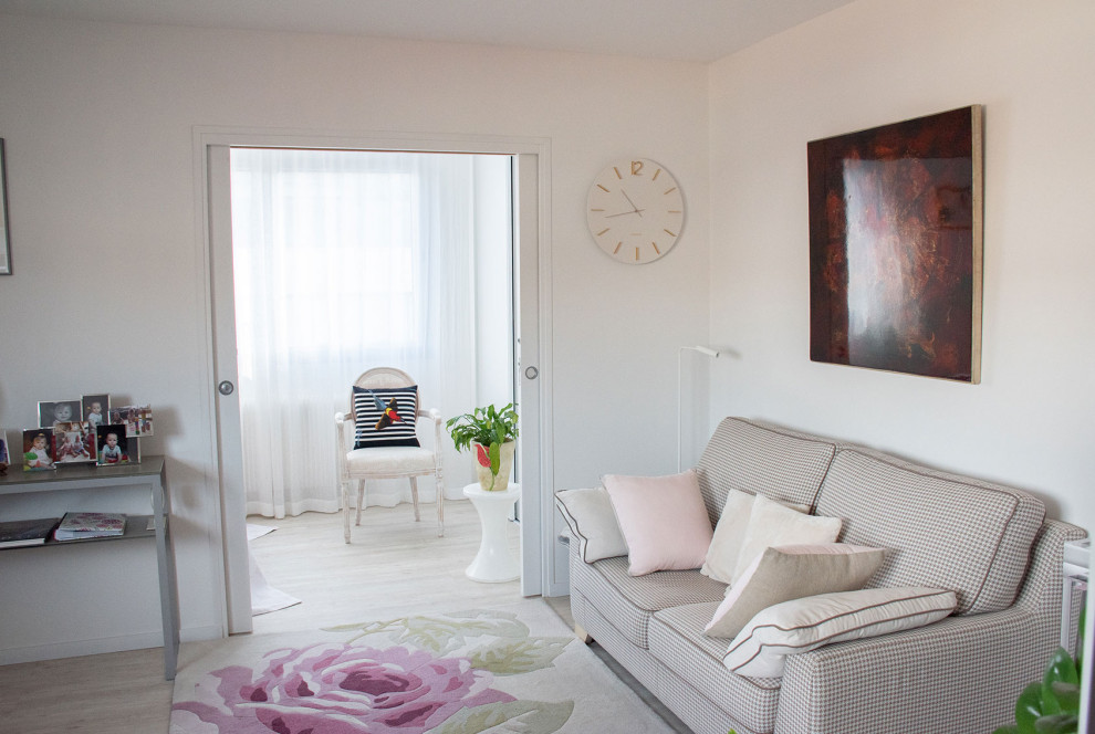 This is an example of a mid-sized traditional open concept living room in Lyon with pink walls, laminate floors and a freestanding tv.