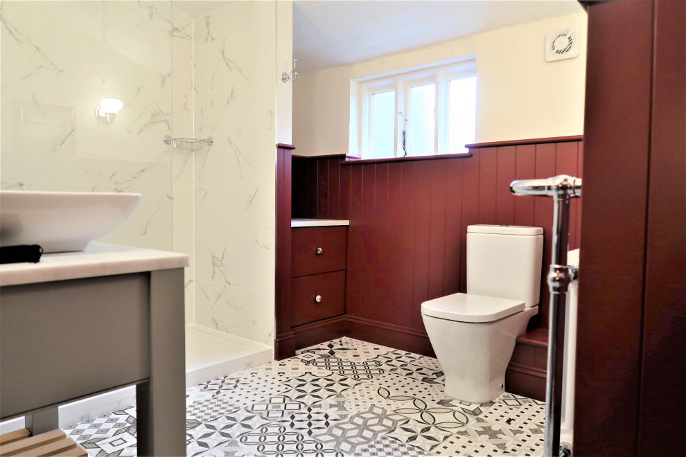 Inredning av ett klassiskt mellanstort vit vitt badrum för barn, med släta luckor, grå skåp, en öppen dusch, en toalettstol med separat cisternkåpa, vit kakel, porslinskakel, röda väggar, klinkergolv i porslin, ett fristående handfat, bänkskiva i kvarts, flerfärgat golv och med dusch som är öppen