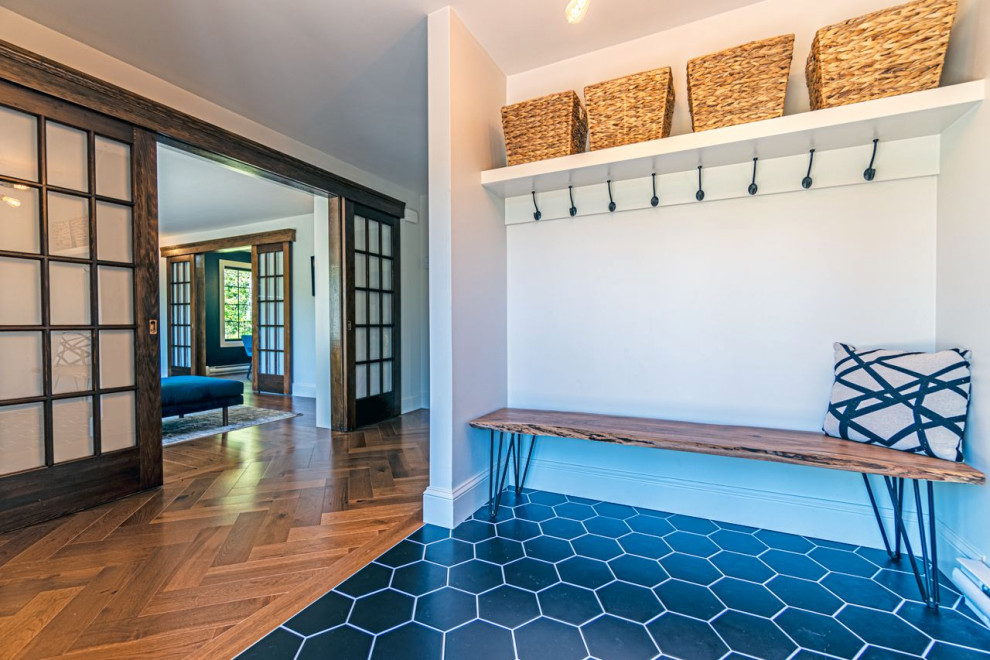 Example of a mid-sized eclectic ceramic tile and black floor foyer design with white walls