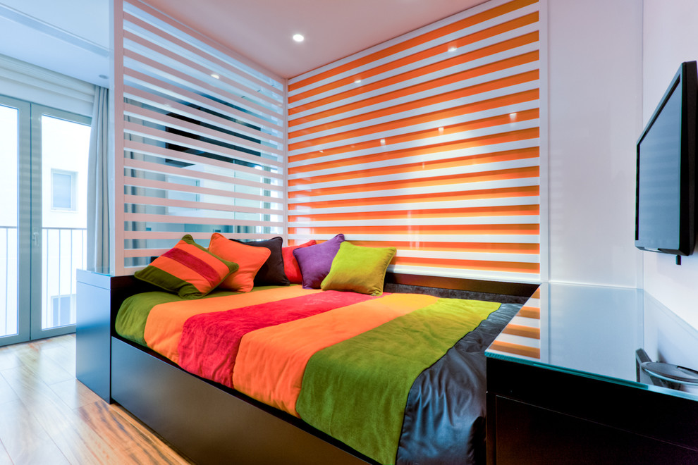 Mediterranean bedroom with orange walls, medium hardwood floors and no fireplace.
