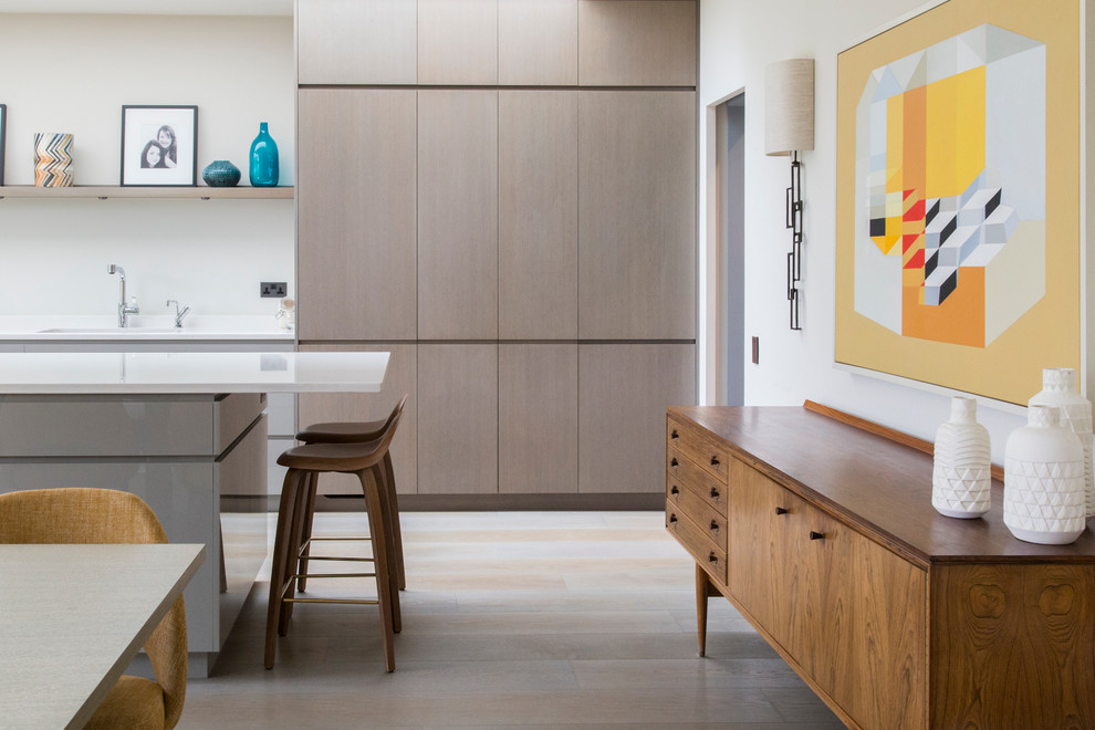 Large midcentury galley eat-in kitchen in London with flat-panel cabinets, light wood cabinets, white splashback, a peninsula and white floor.