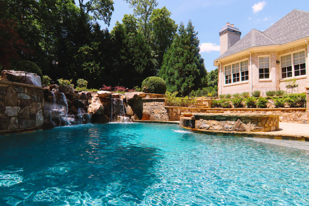 Photo of a large traditional backyard custom-shaped natural pool in Atlanta with with a pool.