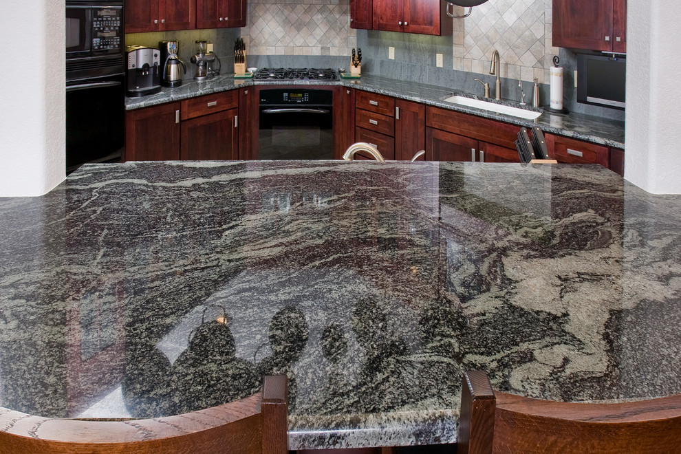 Large transitional l-shaped porcelain tile open concept kitchen photo in Denver with an undermount sink, shaker cabinets, red cabinets, granite countertops, gray backsplash, stone tile backsplash, black appliances and an island