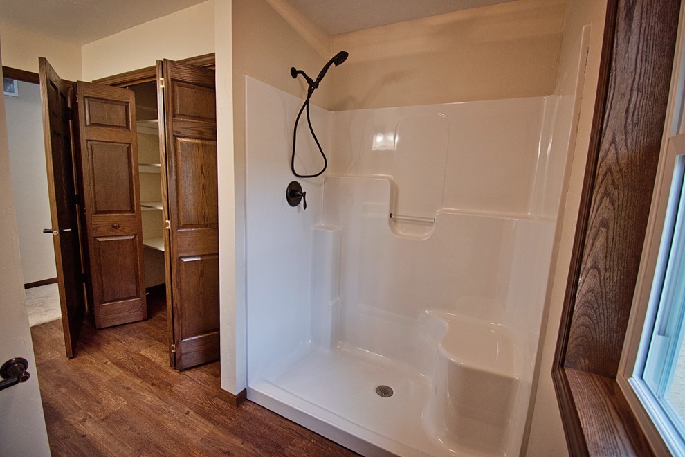 Bathroom - mid-sized transitional medium tone wood floor and brown floor bathroom idea with recessed-panel cabinets, white cabinets, a one-piece toilet, beige walls, a drop-in sink, laminate countertops and beige countertops