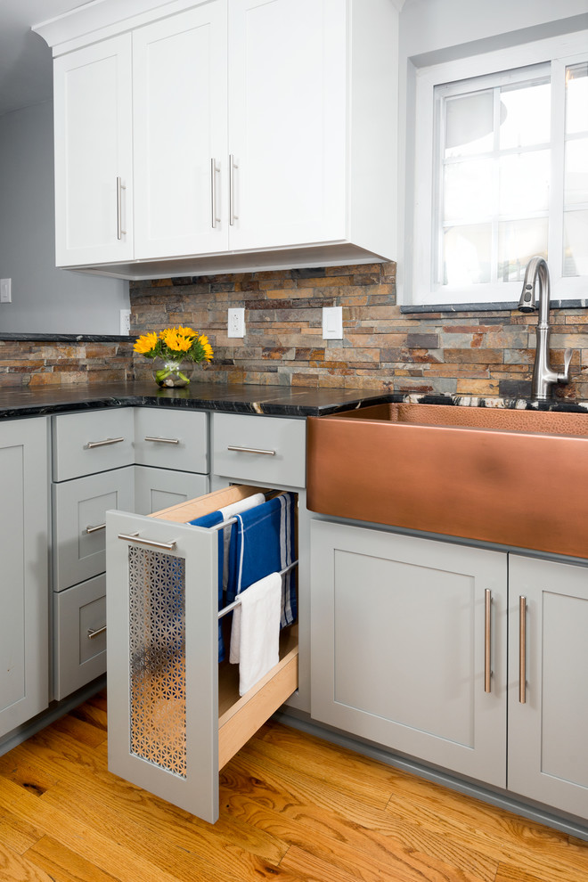 Eat-in kitchen - mid-sized transitional u-shaped medium tone wood floor and beige floor eat-in kitchen idea with a farmhouse sink, shaker cabinets, gray cabinets, marble countertops, multicolored backsplash, stone tile backsplash, stainless steel appliances, a peninsula and black countertops