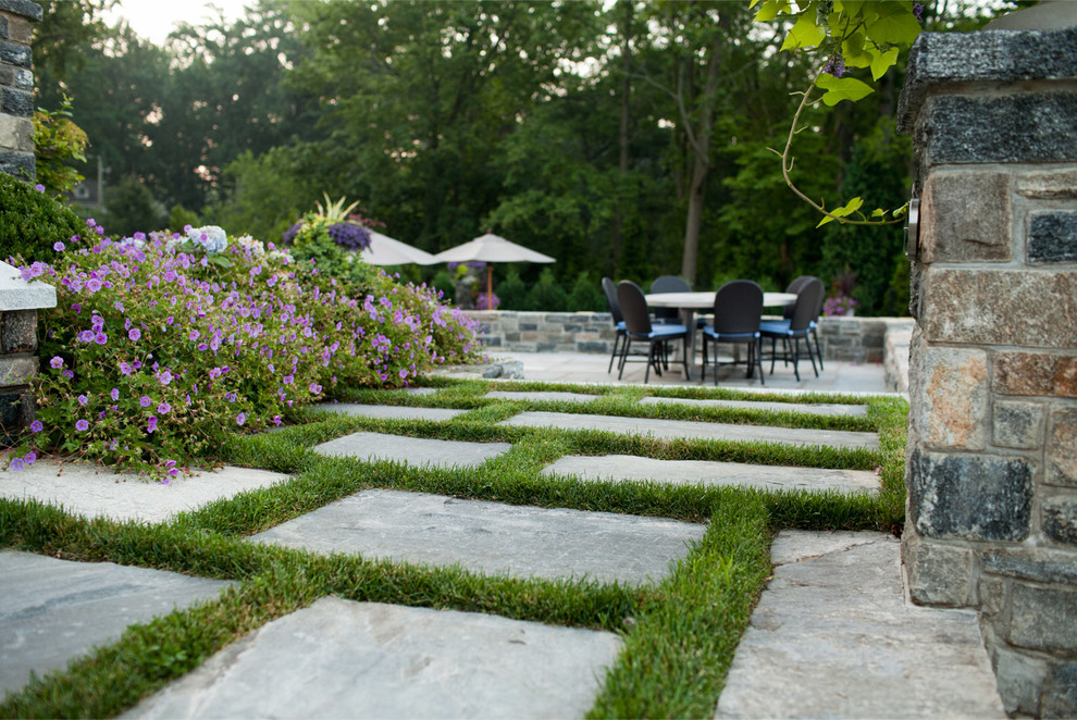 Large transitional backyard stone patio photo in New York with no cover