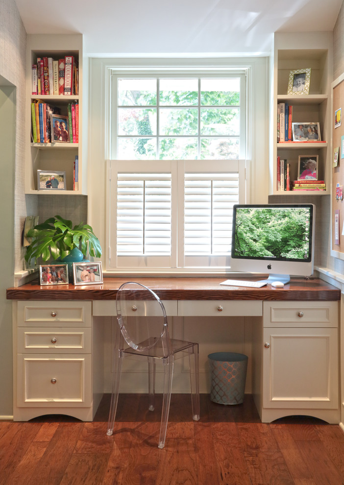 This is an example of a traditional home office in Other with white walls, medium hardwood floors and a built-in desk.