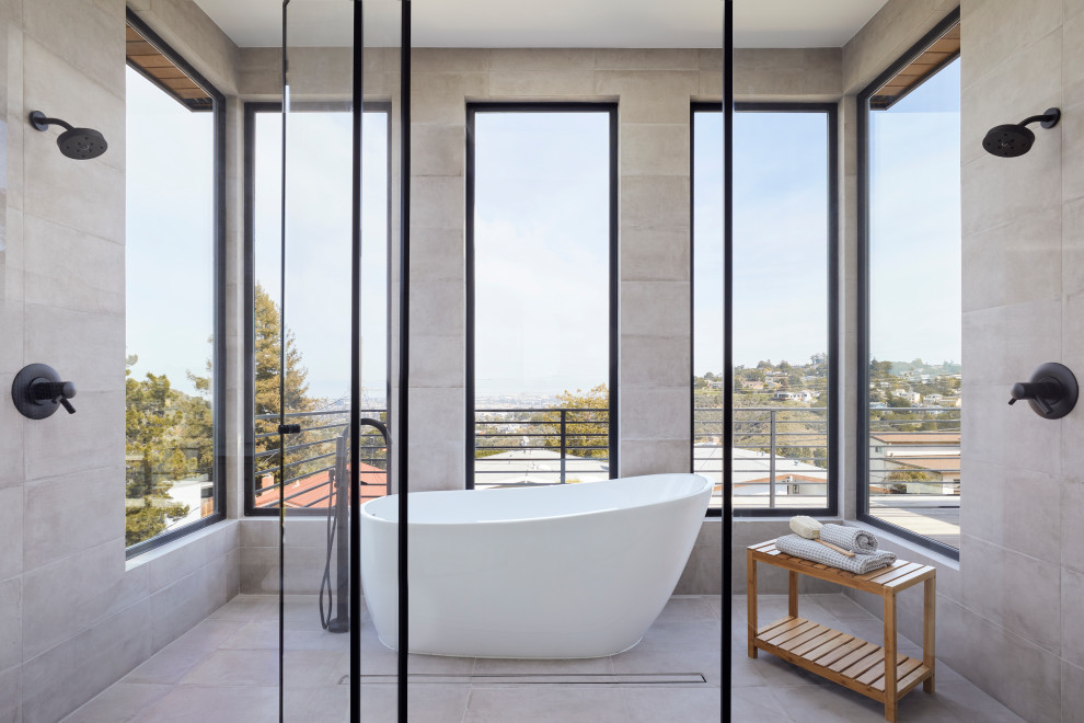 Photo of a large modern master wet room bathroom in San Francisco with a freestanding tub, gray tile, porcelain tile, porcelain floors, grey floor, a hinged shower door, brown cabinets, white walls, an undermount sink, engineered quartz benchtops, white benchtops, a double vanity and a freestanding vanity.