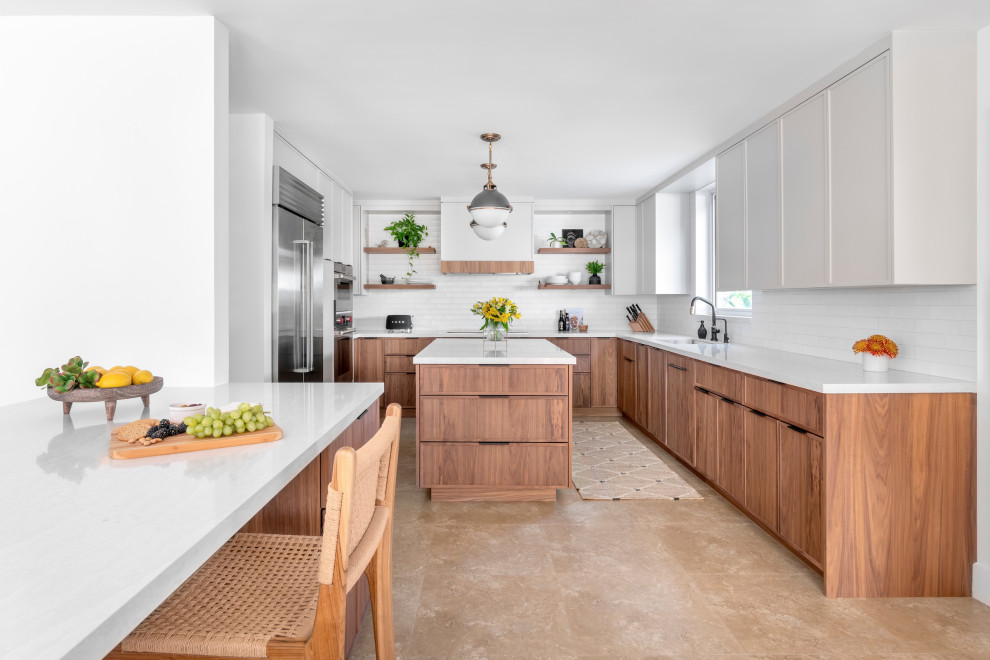 Photo of a large transitional u-shaped kitchen in Other with an undermount sink, flat-panel cabinets, medium wood cabinets, quartz benchtops, beige splashback, ceramic splashback, stainless steel appliances, travertine floors, with island, beige floor and white benchtop.