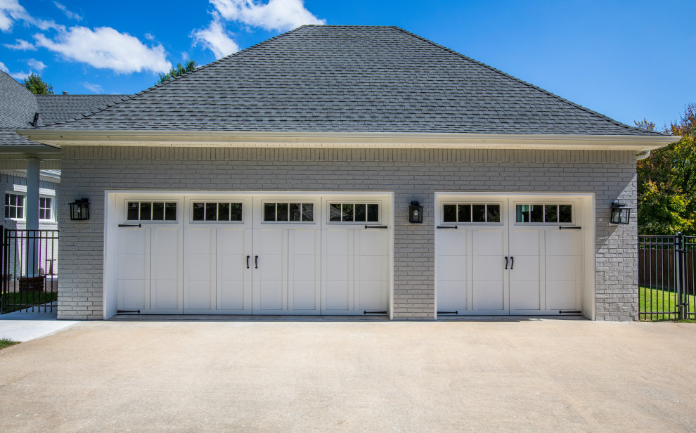 Photo of a large transitional detached three-car garage in Other.