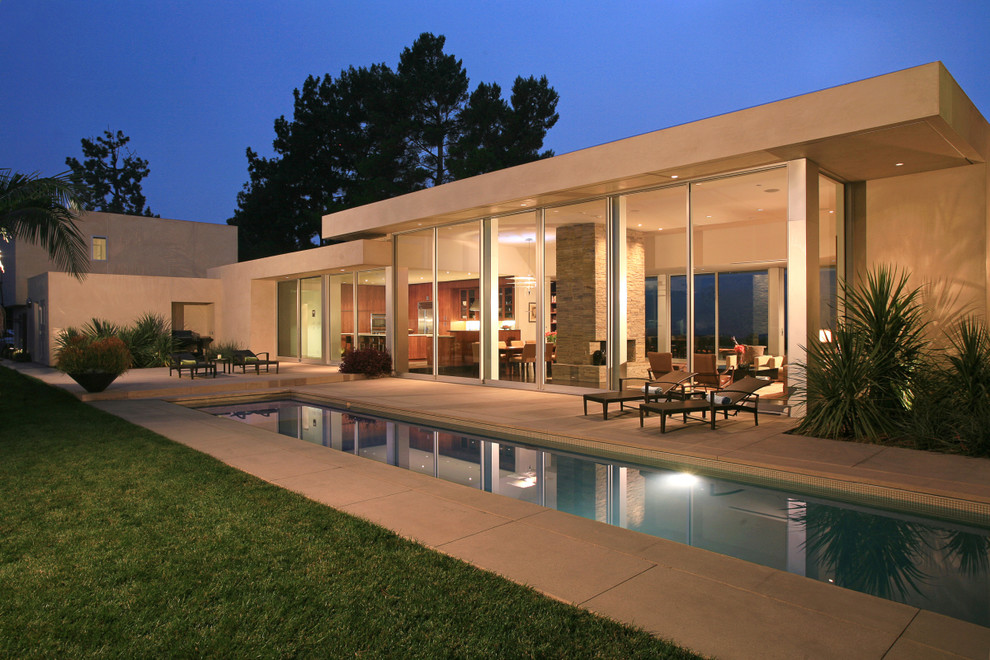 This is an example of a mid-sized modern one-storey glass exterior in Los Angeles with a flat roof.