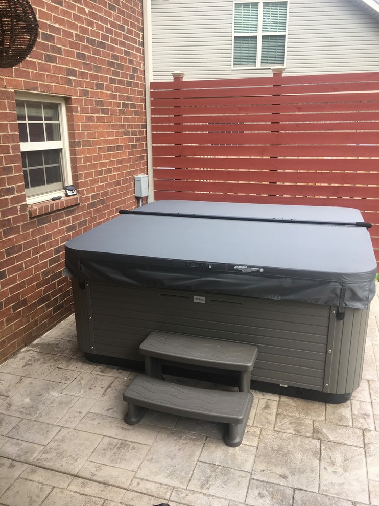 Mid-sized transitional backyard stamped concrete and rectangular hot tub photo