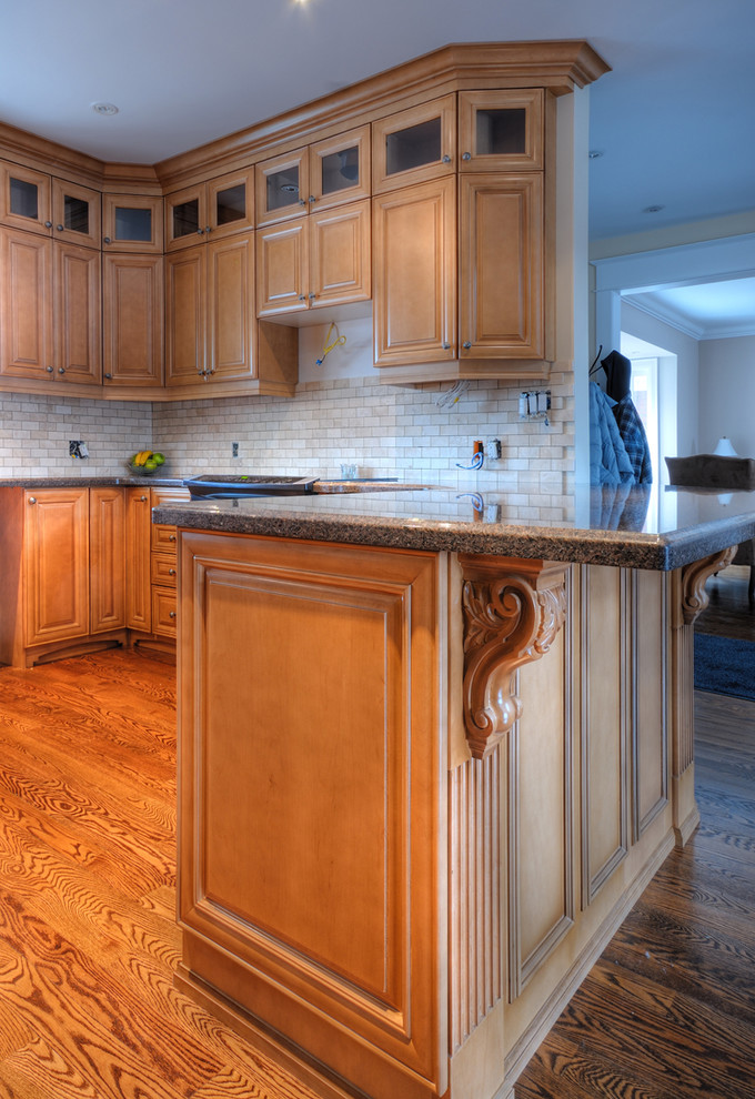 Example of a medium tone wood floor kitchen design in Toronto with light wood cabinets, granite countertops, beige backsplash, stainless steel appliances and no island