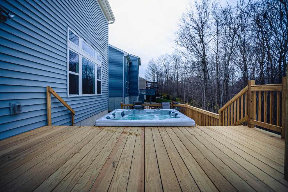 Photo of a mid-sized arts and crafts backyard and ground level deck in Cincinnati with wood railing.
