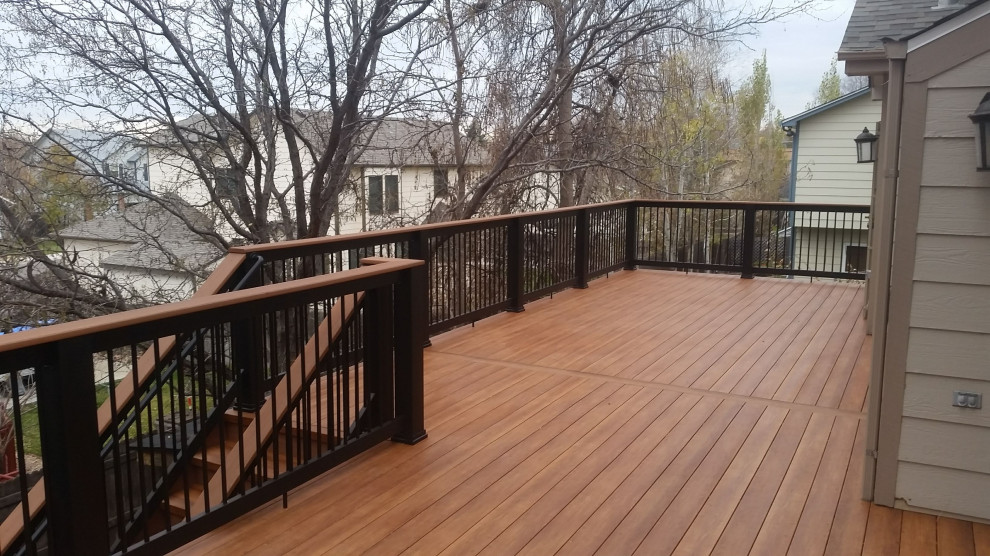 Photo of a mid-sized arts and crafts backyard and first floor deck in Denver with with skirting, no cover and mixed railing.