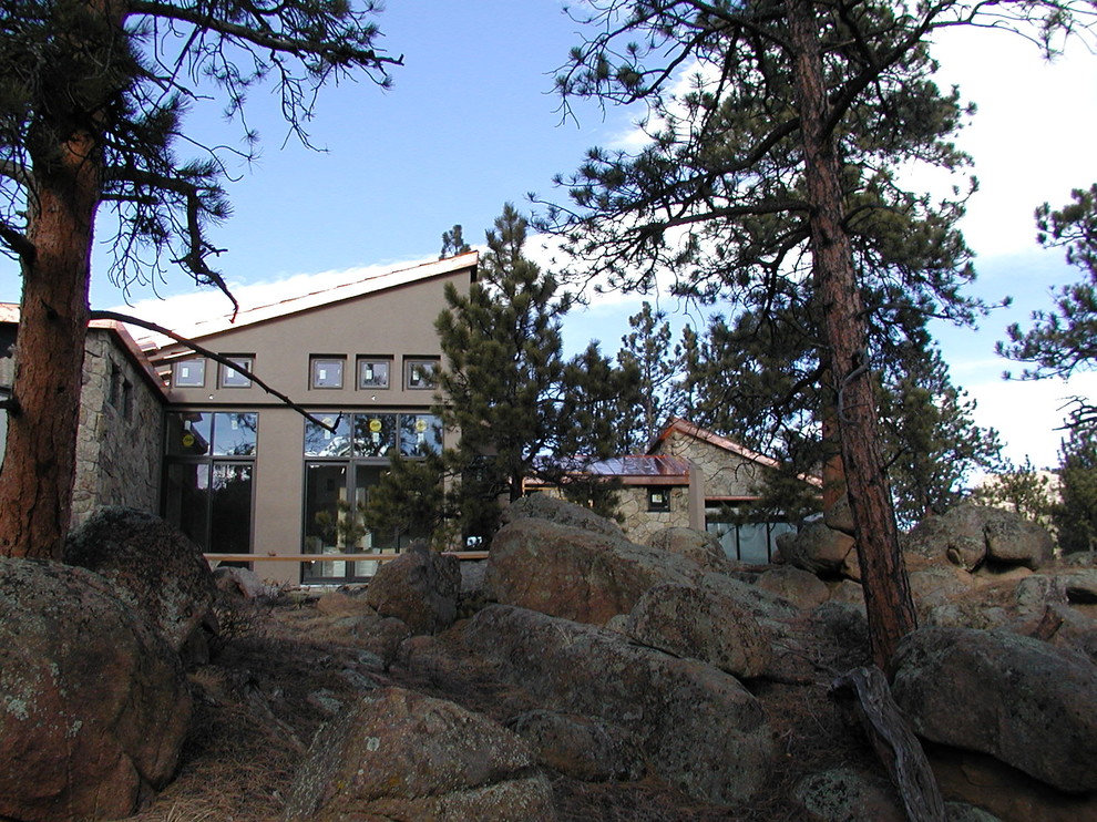 This is an example of a mid-sized contemporary one-storey stucco grey exterior in Denver with a shed roof.