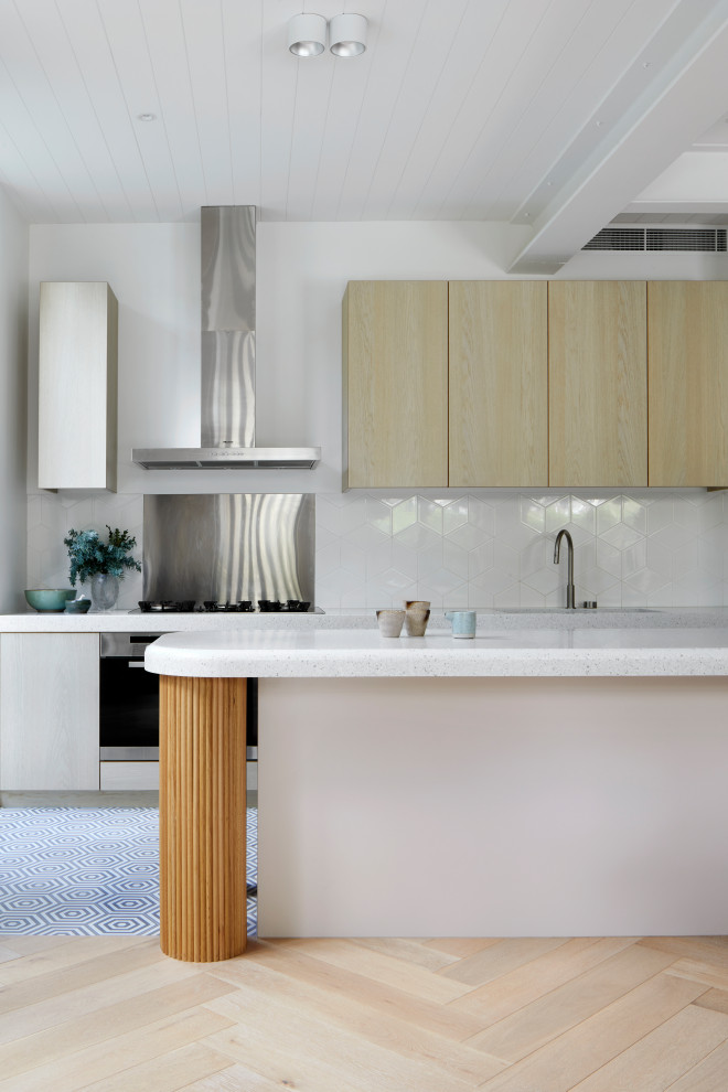 This is an example of a kitchen in Melbourne with light hardwood floors.