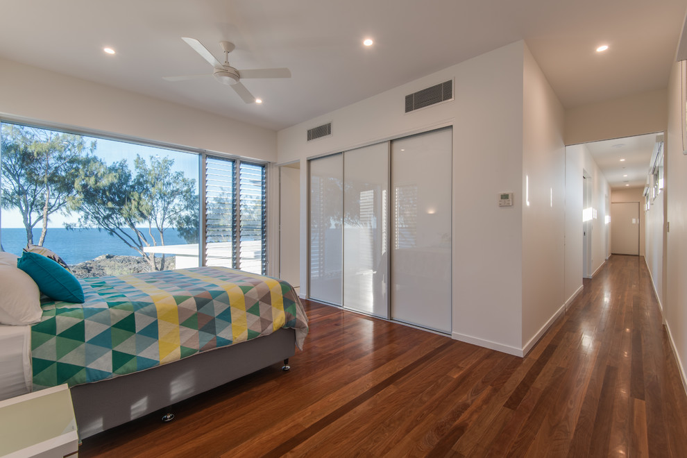 Large modern guest bedroom in Brisbane with white walls and porcelain floors.