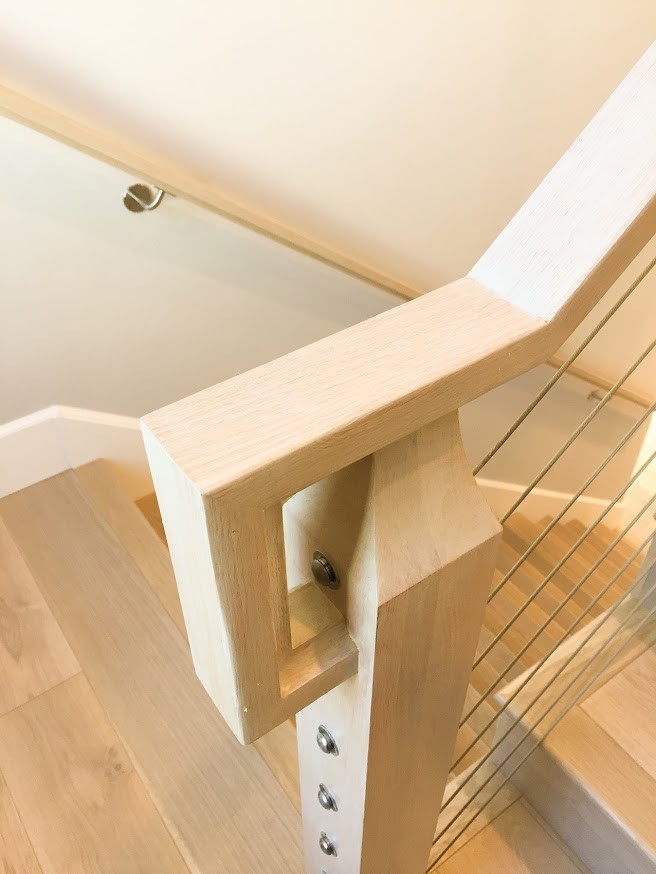 Large modern wood u-shaped staircase in San Francisco with wood risers and mixed railing.