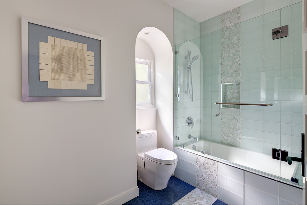 This is an example of a small contemporary bathroom in Los Angeles with recessed-panel cabinets, white cabinets, a shower/bathtub combo, a one-piece toilet, glass tile, white walls, an undermount sink, quartzite benchtops, a drop-in tub, a hinged shower door, porcelain floors and blue floor.