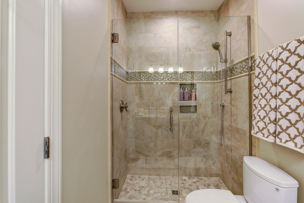 This is an example of a mid-sized transitional 3/4 bathroom in Raleigh with raised-panel cabinets, dark wood cabinets, a corner tub, an open shower, a one-piece toilet, beige tile, brown tile, white tile, stone tile, beige walls, dark hardwood floors, a drop-in sink, marble benchtops and an open shower.