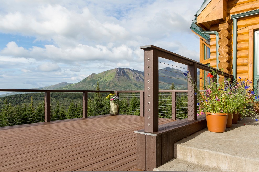 Example of a mid-sized mountain style backyard deck design with no cover
