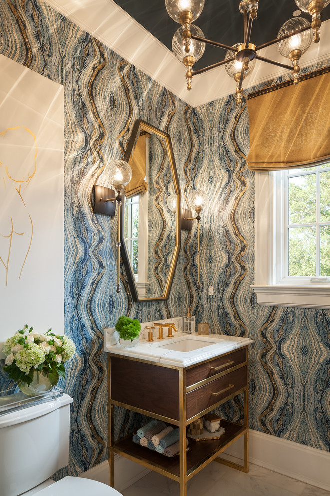 Photo of a mid-sized transitional powder room in New York with a two-piece toilet, blue walls and a console sink.