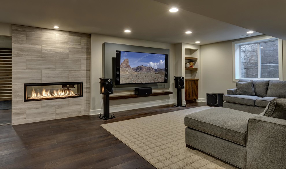 Expansive contemporary look-out basement in Denver with grey walls, dark hardwood floors, a ribbon fireplace, a tile fireplace surround and brown floor.