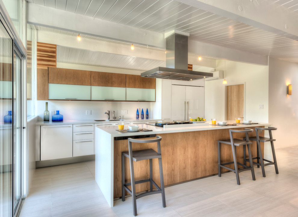 Mid-sized transitional single-wall porcelain tile eat-in kitchen photo in Nice with a single-bowl sink, flat-panel cabinets, white cabinets, solid surface countertops, white backsplash, porcelain backsplash, paneled appliances and an island