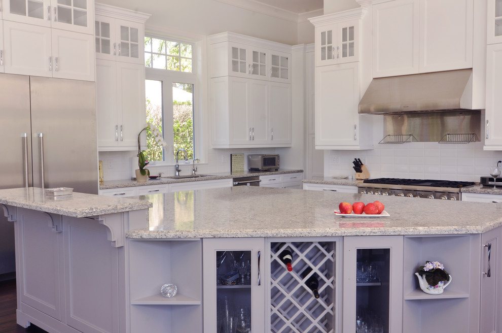 This is an example of a large transitional l-shaped separate kitchen in Miami with a single-bowl sink, recessed-panel cabinets, white cabinets, granite benchtops, white splashback, ceramic splashback, stainless steel appliances and with island.