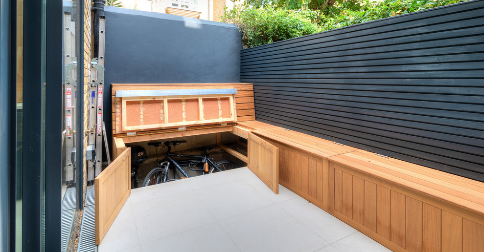 Photo of a small modern backyard patio in London with tile and no cover.