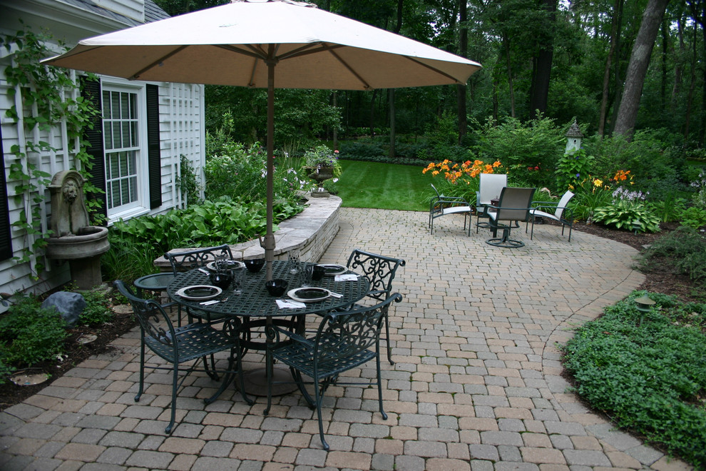 Photo of a mid-sized traditional backyard patio in Chicago with a water feature, brick pavers and no cover.