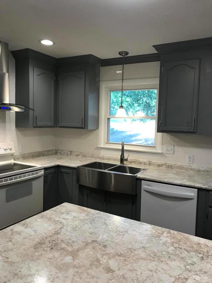Eat-in kitchen - mid-sized transitional l-shaped medium tone wood floor and brown floor eat-in kitchen idea with a farmhouse sink, shaker cabinets, white cabinets, marble countertops, gray backsplash, stainless steel appliances, an island and gray countertops