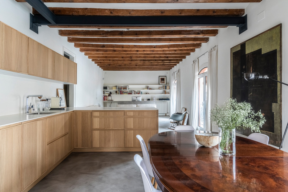 Large world-inspired l-shaped open plan kitchen in Barcelona with a submerged sink, raised-panel cabinets, light wood cabinets, marble worktops, white splashback, marble splashback, stainless steel appliances, concrete flooring, a breakfast bar, grey floors, white worktops and exposed beams.