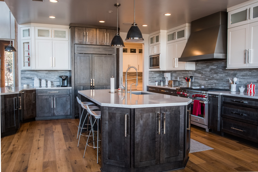 Design ideas for a large country u-shaped open plan kitchen in Phoenix with shaker cabinets, dark wood cabinets, with island, an undermount sink, grey splashback, stone tile splashback, panelled appliances, medium hardwood floors, brown floor and white benchtop.