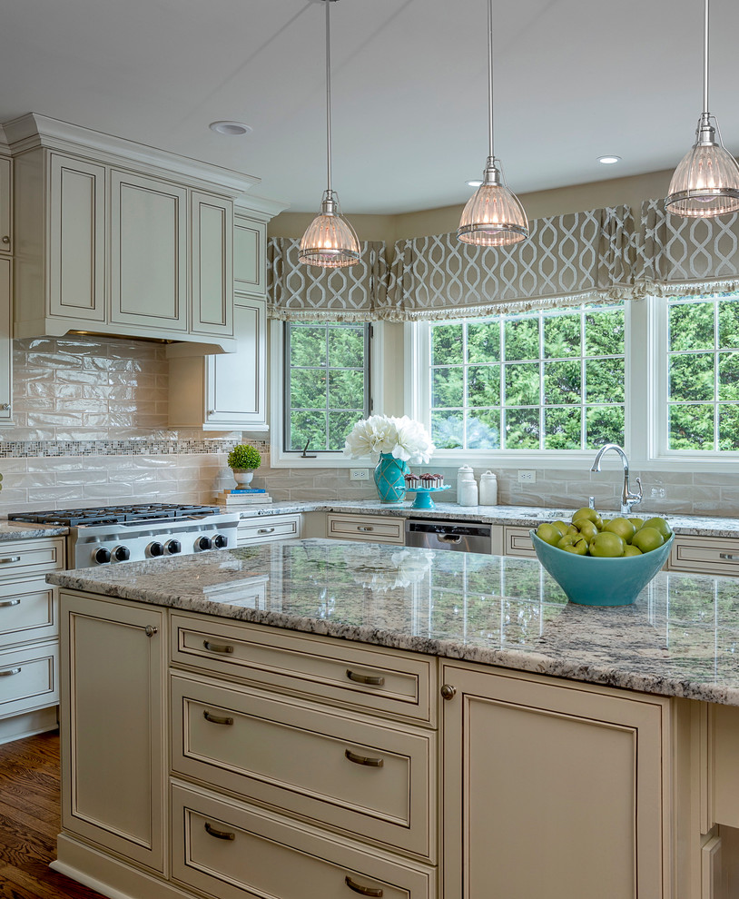 Inspiration for a large traditional l-shaped eat-in kitchen in Baltimore with an undermount sink, recessed-panel cabinets, beige cabinets, granite benchtops, beige splashback, subway tile splashback, stainless steel appliances, medium hardwood floors, with island and brown floor.