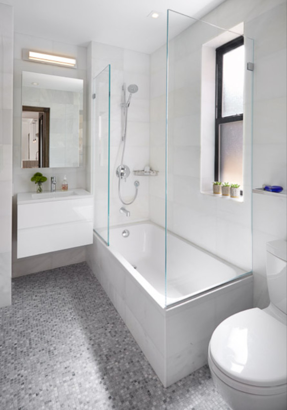 Inspiration for a mid-sized modern 3/4 bathroom in New York with flat-panel cabinets, white cabinets, an alcove tub, a shower/bathtub combo, a two-piece toilet, gray tile, white tile, ceramic tile, white walls, mosaic tile floors, a wall-mount sink, grey floor and an open shower.