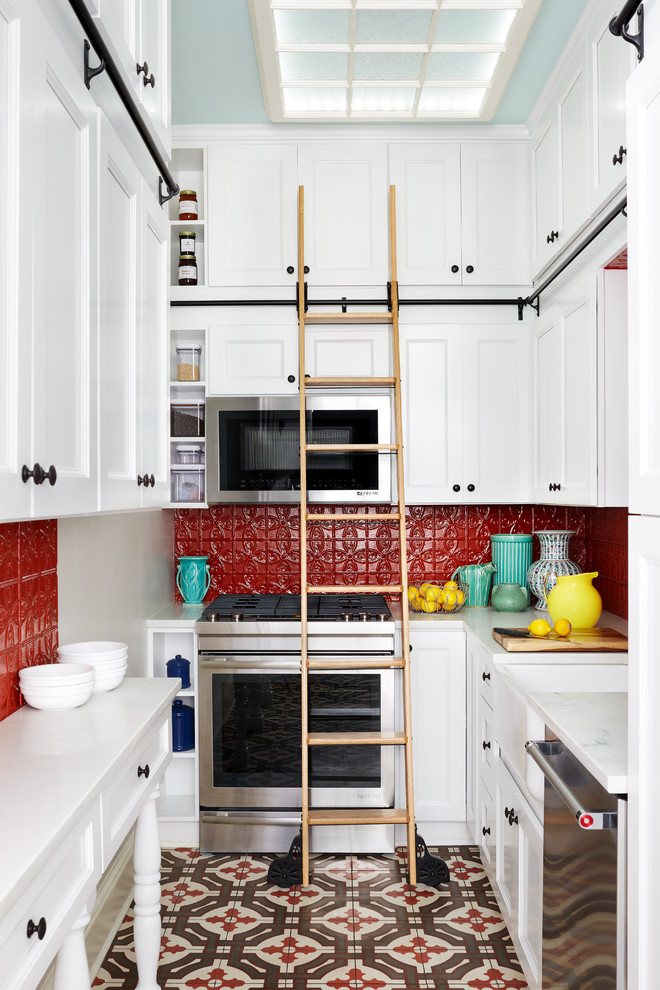 Inspiration for a small transitional u-shaped kitchen in DC Metro with a farmhouse sink, white cabinets, marble benchtops, red splashback, stainless steel appliances, no island, multi-coloured floor, recessed-panel cabinets and metal splashback.