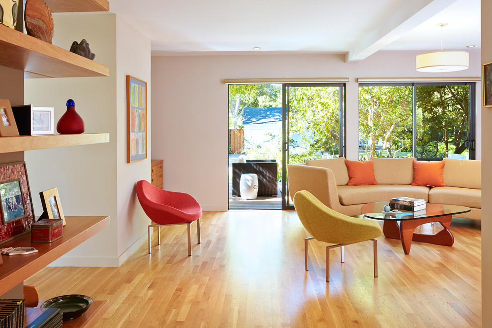 This is an example of a midcentury living room in San Francisco with light hardwood floors.