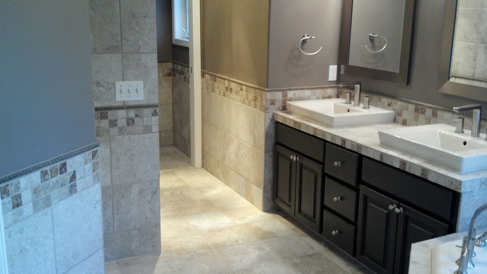 Inspiration for a mid-sized transitional master beige tile and ceramic tile ceramic tile and beige floor claw-foot bathtub remodel in Seattle with raised-panel cabinets, black cabinets, a two-piece toilet, gray walls and tile countertops