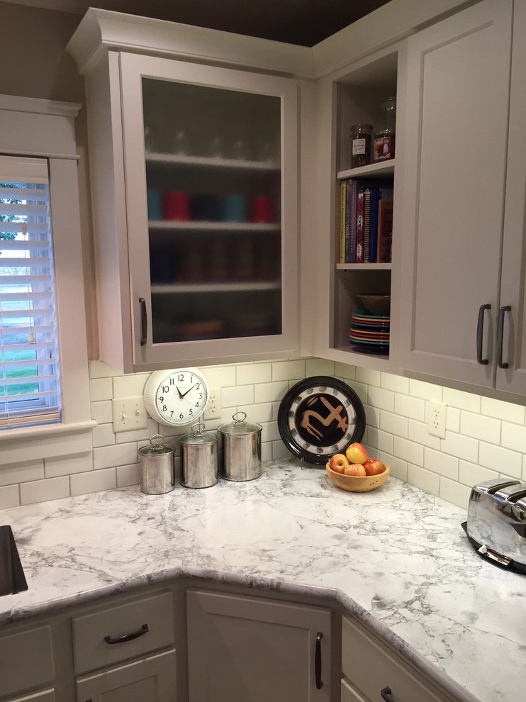Inspiration for a mid-sized transitional u-shaped medium tone wood floor eat-in kitchen remodel with an integrated sink, shaker cabinets, white cabinets, laminate countertops, white backsplash, subway tile backsplash, stainless steel appliances and a peninsula