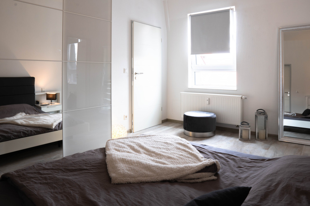 На фото: хозяйская, серо-белая спальня среднего размера в стиле модернизм с белыми стенами, полом из винила и серым полом
