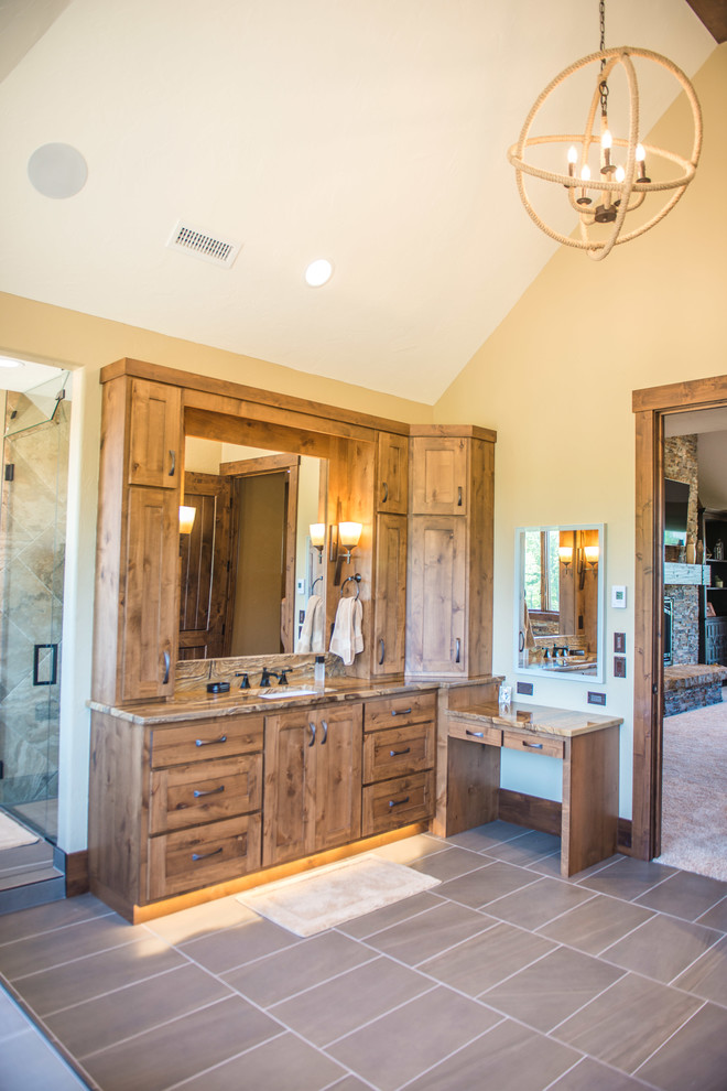 Photo of an expansive country master bathroom in Chicago with flat-panel cabinets, medium wood cabinets, a freestanding tub, an open shower, a one-piece toilet, slate, multi-coloured walls, porcelain floors, an undermount sink, marble benchtops, brown floor and a hinged shower door.