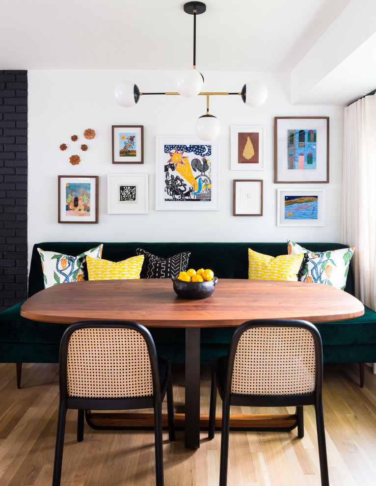 Ispirazione per una piccola sala da pranzo aperta verso la cucina moderna con pareti bianche, parquet chiaro e pavimento marrone