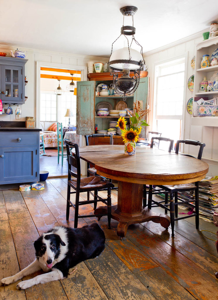 Design ideas for a country kitchen/dining combo in New York with white walls, dark hardwood floors and brown floor.